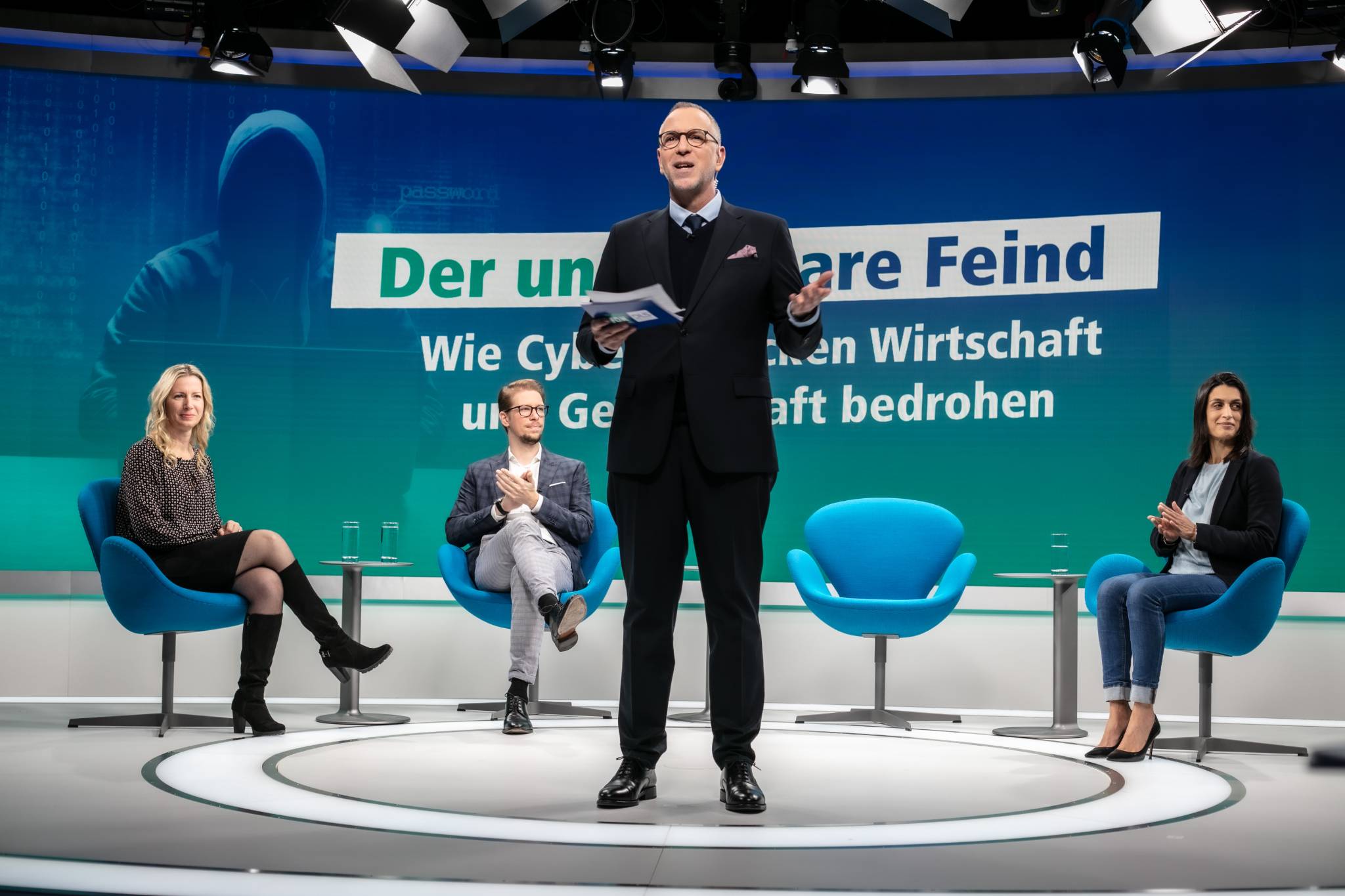 Moderator bei Podiumsdiskussion im TV-Studio
