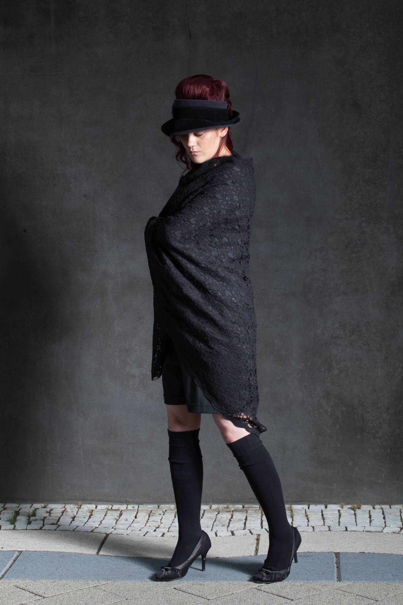 Model in schwarzem Umhang, Kappe