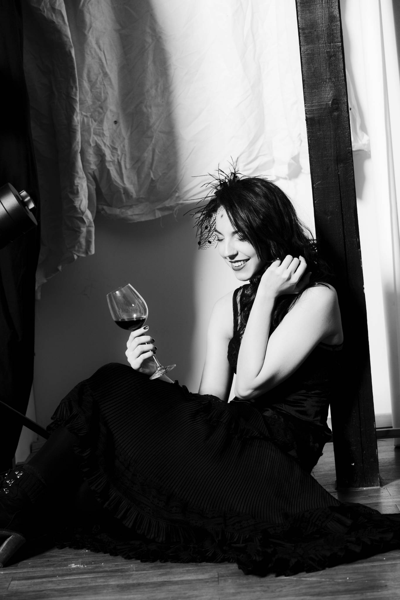 Frau im schwarzen Kleid sitzend, Weinglas