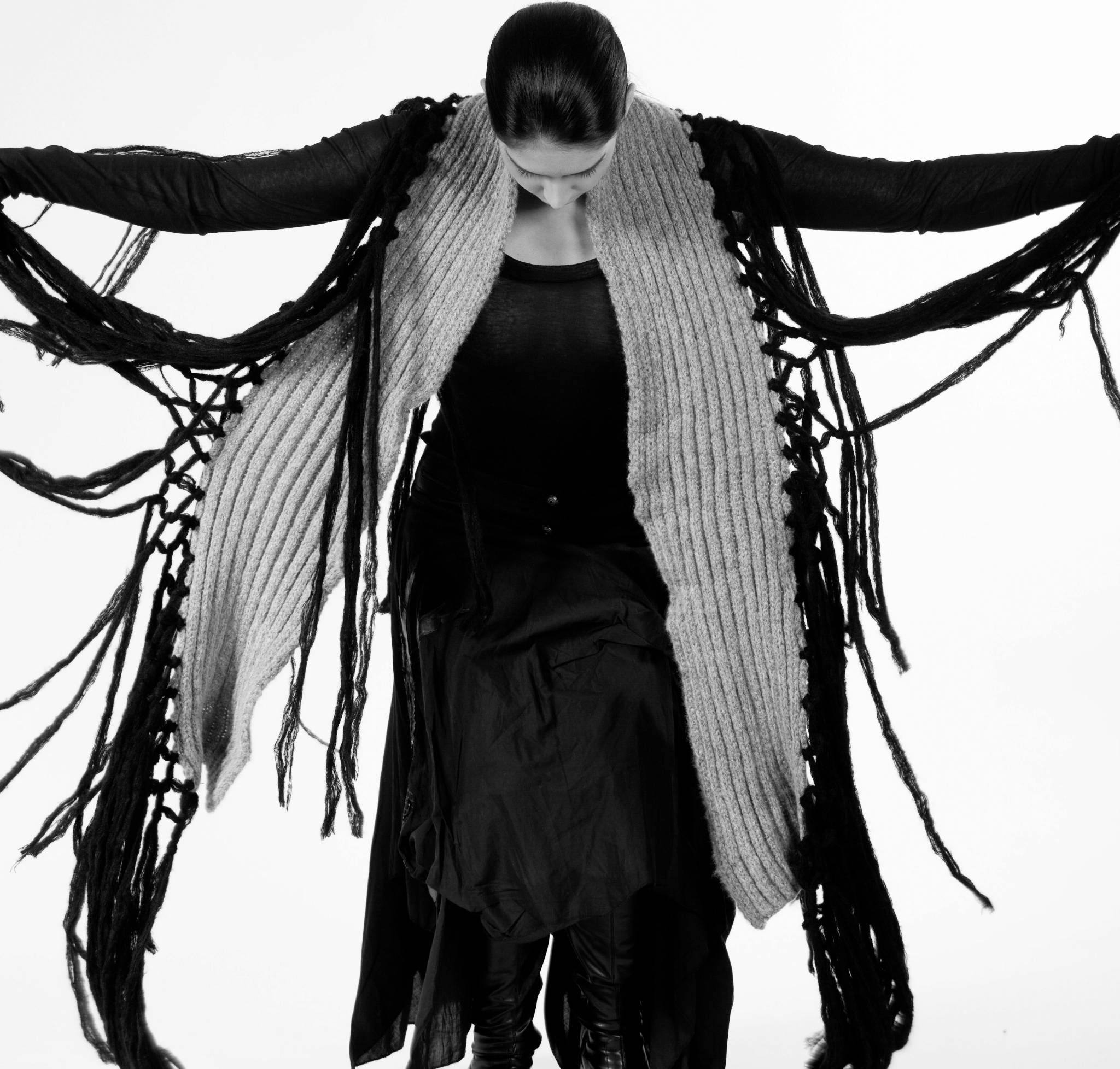 Frau im Strickkleid breitet Arme aus