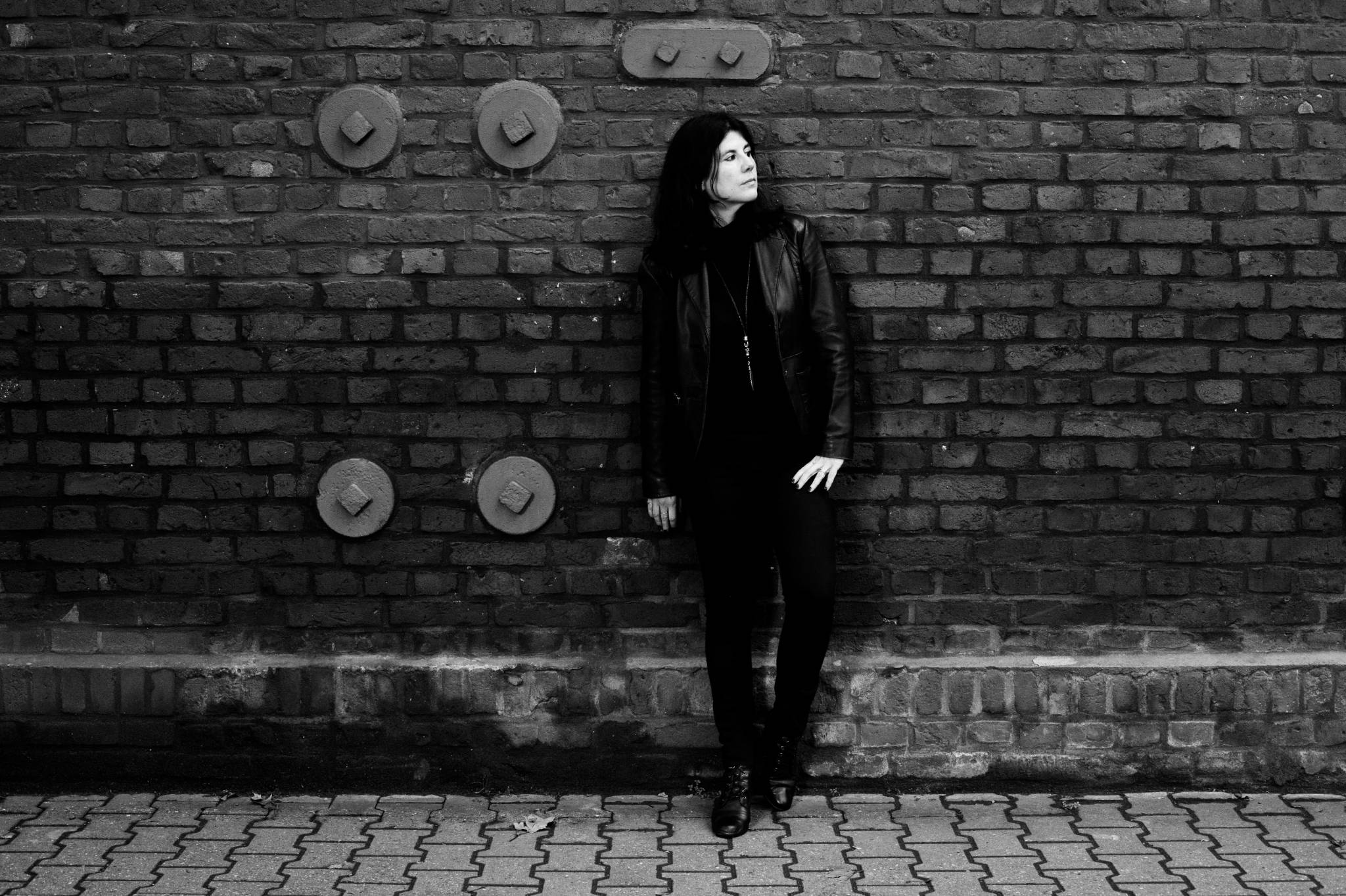 Frau an Mauer, coole Pose